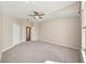 Large carpeted bedroom featuring a ceiling fan, closet, and view of the en-suite bathroom at 5131 Gato Del Sol Cir, Wesley Chapel, FL 33544