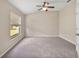 Bedroom with a neutral carpet, window, and ceiling fan at 5131 Gato Del Sol Cir, Wesley Chapel, FL 33544