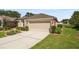 Well-maintained house with a two-car garage, concrete driveway, and a green lawn at 5131 Gato Del Sol Cir, Wesley Chapel, FL 33544