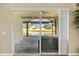 View from inside to the screened patio overlooking the lake and outdoor furniture at 5131 Gato Del Sol Cir, Wesley Chapel, FL 33544