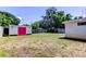A lush backyard featuring a shed with a pink door, a sturdy fence, and ample green space at 565 55Th Ne Ave, St Petersburg, FL 33703