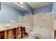 Bathroom with blue walls, a tub, a toilet, and unfinished drywall ready to be renovated at 565 55Th Ne Ave, St Petersburg, FL 33703