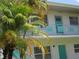 Building's exterior showcases modern teal doors, white walls, and lush palm trees, blending modern style with tropical charm at 5970 21St N St # 15, St Petersburg, FL 33714