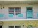 Balcony view of unit's exterior with a teal door and decorative accents, offering a modern aesthetic at 5970 21St N St # 15, St Petersburg, FL 33714