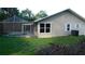 Backyard view of home with screened pool, patio and an air conditioning unit at 6605 Foxmoor Dr, Zephyrhills, FL 33542