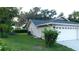 Exterior view of home featuring a spacious garage and well-maintained lawn at 6605 Foxmoor Dr, Zephyrhills, FL 33542