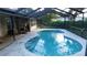 Sparkling pool in screened enclosure, featuring a modern design and tiled edge at 6605 Foxmoor Dr, Zephyrhills, FL 33542