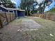 Backyard features a new fence, home with blue siding, green grass, and mature trees providing shade at 8018 Mulberry St, Tampa, FL 33604