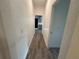 Hallway with wood grain vinyl flooring, white walls and a view to the updated kitchen at 8018 Mulberry St, Tampa, FL 33604