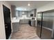 Updated kitchen features gray cabinetry, stainless steel appliances, quartz countertops and wood grain vinyl flooring at 8018 Mulberry St, Tampa, FL 33604