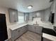Updated kitchen features gray cabinetry, stainless steel appliances, quartz countertops and wood grain vinyl flooring at 8018 Mulberry St, Tampa, FL 33604