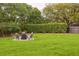Well-manicured backyard featuring a seating area around a fire pit and an open green space at 803 Brooker Village Cir, Lutz, FL 33548
