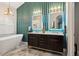 This bathroom has marble floors, a modern soaking tub, double vanity and unique light fixtures at 803 Brooker Village Cir, Lutz, FL 33548