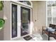 Covered front porch featuring decorative glass door and side lights, bench, and textured wall at 803 Brooker Village Cir, Lutz, FL 33548
