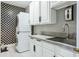 Laundry room featuring stacked washer and dryer units, storage cabinets, and a utility sink at 803 Brooker Village Cir, Lutz, FL 33548