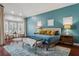 Bedroom featuring blue walls, wood floors, a sitting area and an accent window at 803 Brooker Village Cir, Lutz, FL 33548