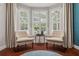 The naturally lit sitting area features hardwood floors, plantation shutters, and two armchairs at 803 Brooker Village Cir, Lutz, FL 33548