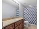 Bathroom showcasing a granite countertop, wood cabinets, and a shower-tub combo at 8836 Alafia Cove Dr, Riverview, FL 33569
