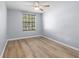 Cozy bedroom featuring sleek, modern wood-look floors and a window at 8836 Alafia Cove Dr, Riverview, FL 33569