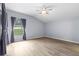 Bright bedroom with a ceiling fan and a large window overlooking the manicured lawn at 8836 Alafia Cove Dr, Riverview, FL 33569