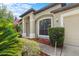 Close up of home exterior with arched window, columns, green shrubbery, and front yard at 8836 Alafia Cove Dr, Riverview, FL 33569