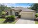 Charming home featuring a two-car garage, landscaped yard, and manicured bushes at 8836 Alafia Cove Dr, Riverview, FL 33569