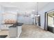 Bright kitchen with white cabinets, black countertops, and an eat-in bar area, flowing into the living room at 8836 Alafia Cove Dr, Riverview, FL 33569
