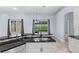 Kitchen island with black granite counters and a sink with stainless steel appliances and view to the pool at 8836 Alafia Cove Dr, Riverview, FL 33569