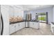 Well-lit kitchen boasts white cabinets, black countertops, and a view of the outdoor pool area at 8836 Alafia Cove Dr, Riverview, FL 33569