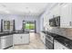 Kitchen with granite countertops, stainless steel appliances, white cabinets, and pool view at 8836 Alafia Cove Dr, Riverview, FL 33569