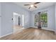 Living room with hardwood floors, a ceiling fan and a large window with neutral colored curtains at 8836 Alafia Cove Dr, Riverview, FL 33569