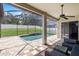 Rear view of the screened-in pool, waterfall feature, and rear privacy fence at 8836 Alafia Cove Dr, Riverview, FL 33569