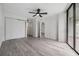 Spacious bedroom with ceiling fan, closet, and view of the outdoor greenery at 900 Cove Cay Dr # 1B, Clearwater, FL 33760