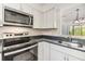 Modern kitchen featuring stainless steel appliances, and black countertops at 900 Cove Cay Dr # 1B, Clearwater, FL 33760