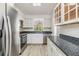 Bright kitchen featuring stainless steel appliances, granite countertops, and wood look flooring at 900 Cove Cay Dr # 1B, Clearwater, FL 33760