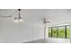 Bright living room with neutral paint, ceiling fan and view of the outdoor greenery at 900 Cove Cay Dr # 1B, Clearwater, FL 33760