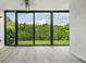 Living room with light gray floors, ceiling fan and view of the outdoor greenery at 900 Cove Cay Dr # 1B, Clearwater, FL 33760