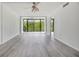 Bright living room featuring neutral paint, light gray flooring and view of greenery through large windows at 900 Cove Cay Dr # 1B, Clearwater, FL 33760