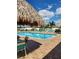 Large swimming pool featuring inviting, clear water and several lounge chairs under a Tiki hut at 900 Cove Cay Dr # 1B, Clearwater, FL 33760