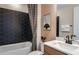 Elegant bathroom featuring a bathtub with geometric tile accent wall and stylish vanity at 10305 Cross River Trl, Parrish, FL 34219
