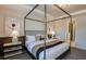 A cozy bedroom featuring a four-poster bed, neutral color palette, and stylish decor at 10305 Cross River Trl, Parrish, FL 34219