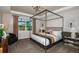 Beautiful bedroom featuring a stylish four-poster bed, large window, and modern lighting at 10305 Cross River Trl, Parrish, FL 34219