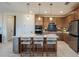 Modern kitchen featuring a large island with seating, stainless steel appliances, and stylish pendant lighting at 10305 Cross River Trl, Parrish, FL 34219