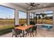 Relaxing covered patio with dining table and chairs overlooking the lush green outdoor space and a calming water feature at 10305 Cross River Trl, Parrish, FL 34219