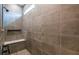 Contemporary shower featuring sleek brown tile, bench, and a window letting in natural light at 10305 Cross River Trl, Parrish, FL 34219