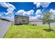 Large backyard with a white fence, green lawn, landscaping, and seating area at 10360 Blue Plume Ct, Riverview, FL 33578