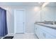 Well-lit bathroom with double sinks, granite countertops, and a shower with blue curtains at 10360 Blue Plume Ct, Riverview, FL 33578