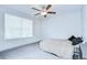 Bright bedroom features a ceiling fan and a large window with horizontal blinds at 10360 Blue Plume Ct, Riverview, FL 33578