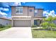 Charming two-story home with a two-car garage, tidy landscaping, and a welcoming blue front door at 10360 Blue Plume Ct, Riverview, FL 33578