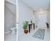 Hallway with a half-bath, tile flooring, console table, and a white front door at 10360 Blue Plume Ct, Riverview, FL 33578
